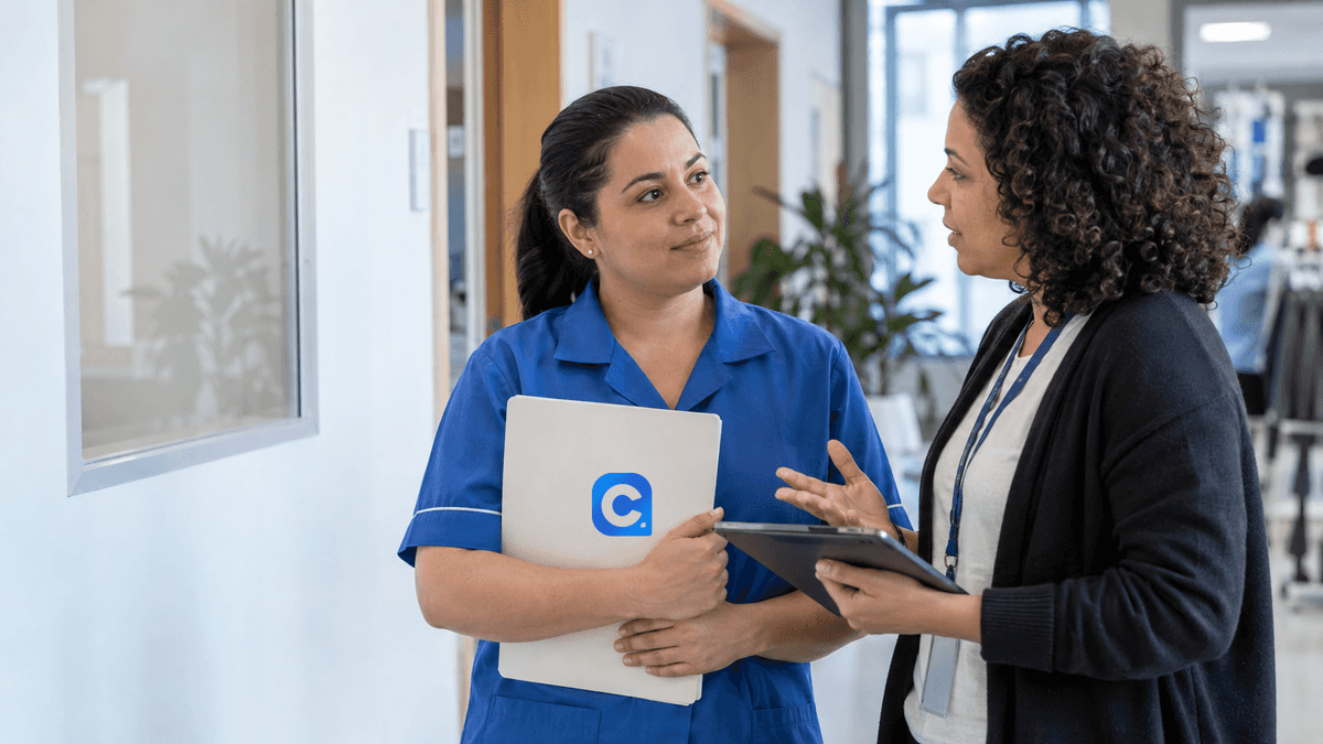 Empregada adulta em uniforme azul conversa com profissional de RH e segura uma pasta com o símbolo oficial do Meu Consig.